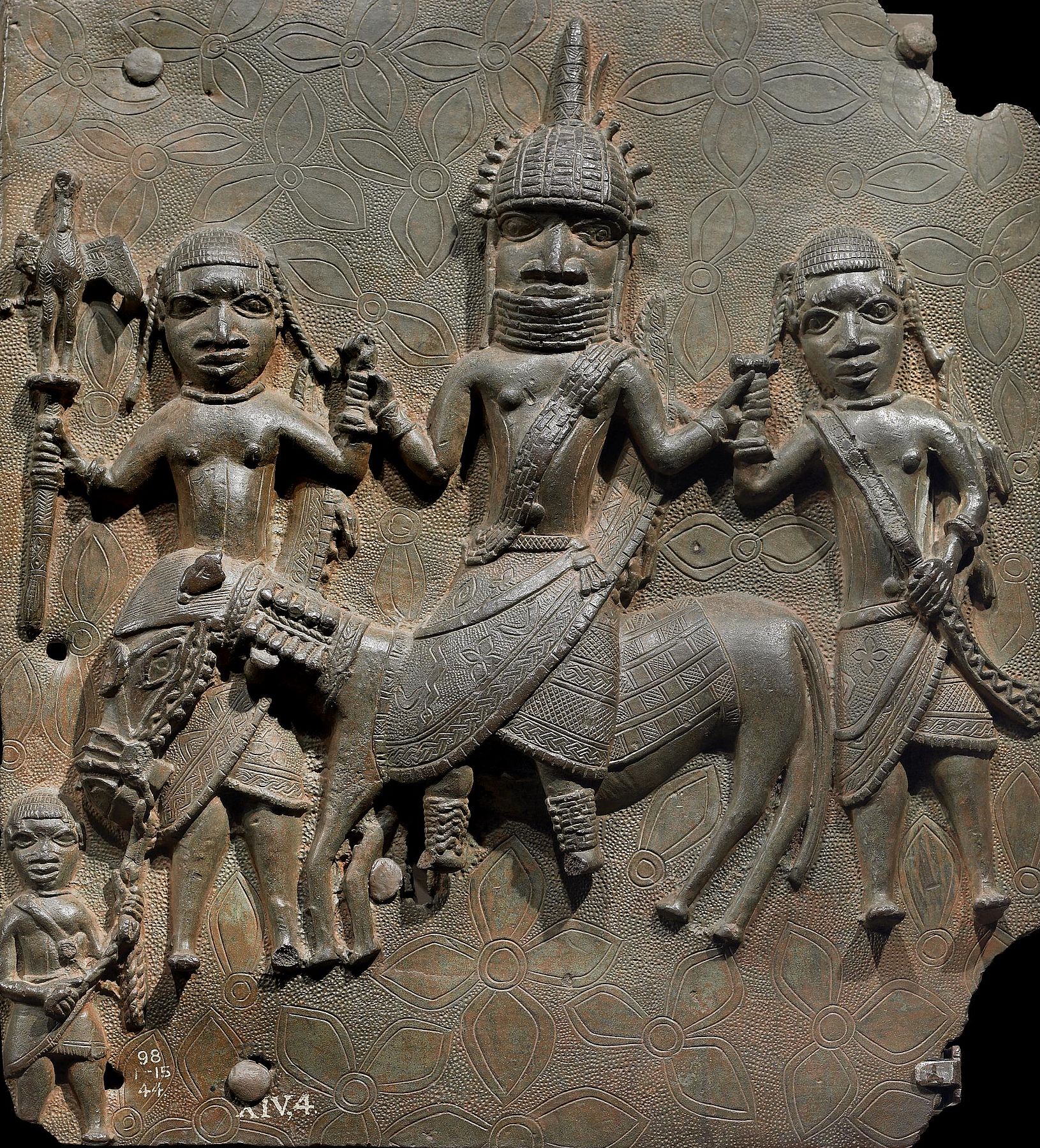 Oba à cheval, de face, tenant les poignets de deux pages