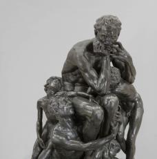 un homme assis se mordant les mains, des enfants à ses pieds