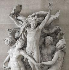 groupe sculpté avec un jeune homme tenant un tambourin entouré de jeunes femmes à demi-nues