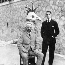 un homme debout et un autre assis, derrière eux une maquette d'oiseau