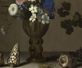 Le gros plan est sur les coquillages et la sauterelle au pieds du vase.