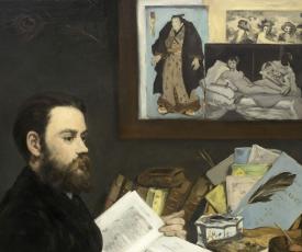 un homme à son bureau avec des livres et des gravures