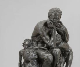 un homme assis se mordant les mains, des enfants à ses pieds