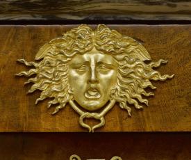 Martin-Guillaume Biennais (1764-1843), secrétaire à abattant. Détail de la tête de Méduse et de l’entrée de serrure en forme de lyre. Vers 1804-1814, ébénisterie (bois, bronze doré), 154 × 75 × 39 cm. Rueil-Malmaison, musée national des châteaux de Malmaison et Bois-Préau (M.M.2013.2.1)