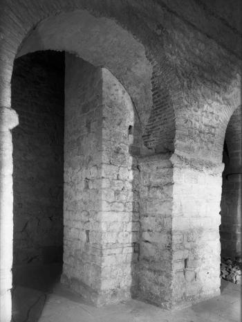 Une photo en noir et blanc montre des arches en pierre massives et des piliers solides dans une structure souterraine historique